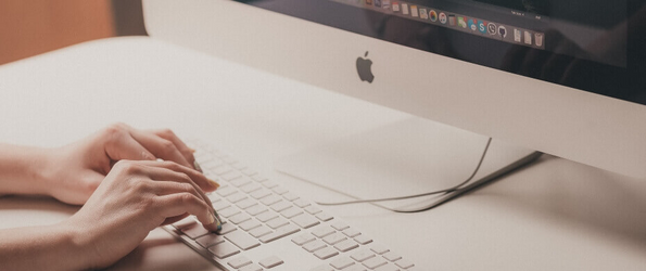 Person arbeitet mit Apple Computer