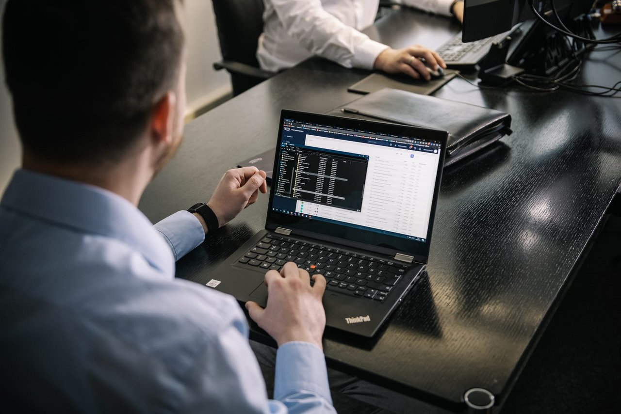 Mitarbeiter arbeitet am Laptop in der Dateiablage