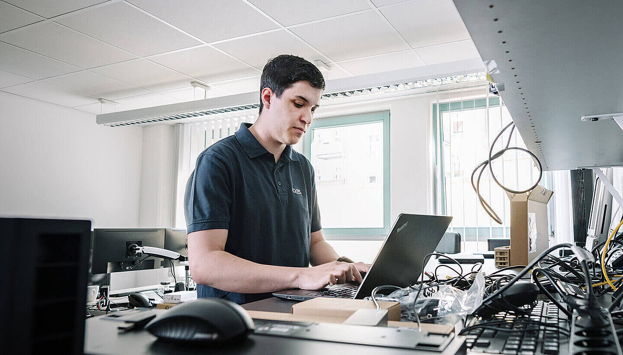 QITEC-Mitarbeiter arbeitet am Laptop im Büro