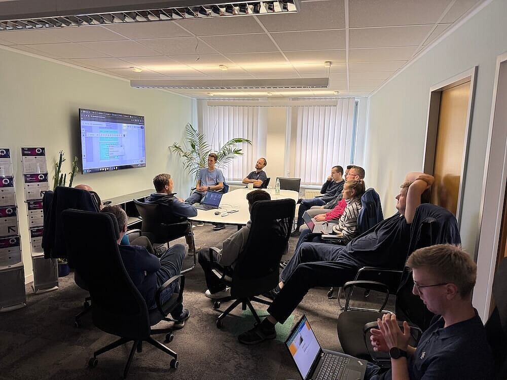 Das QITEC-Team bei einer Besprechung im Konferenzraum