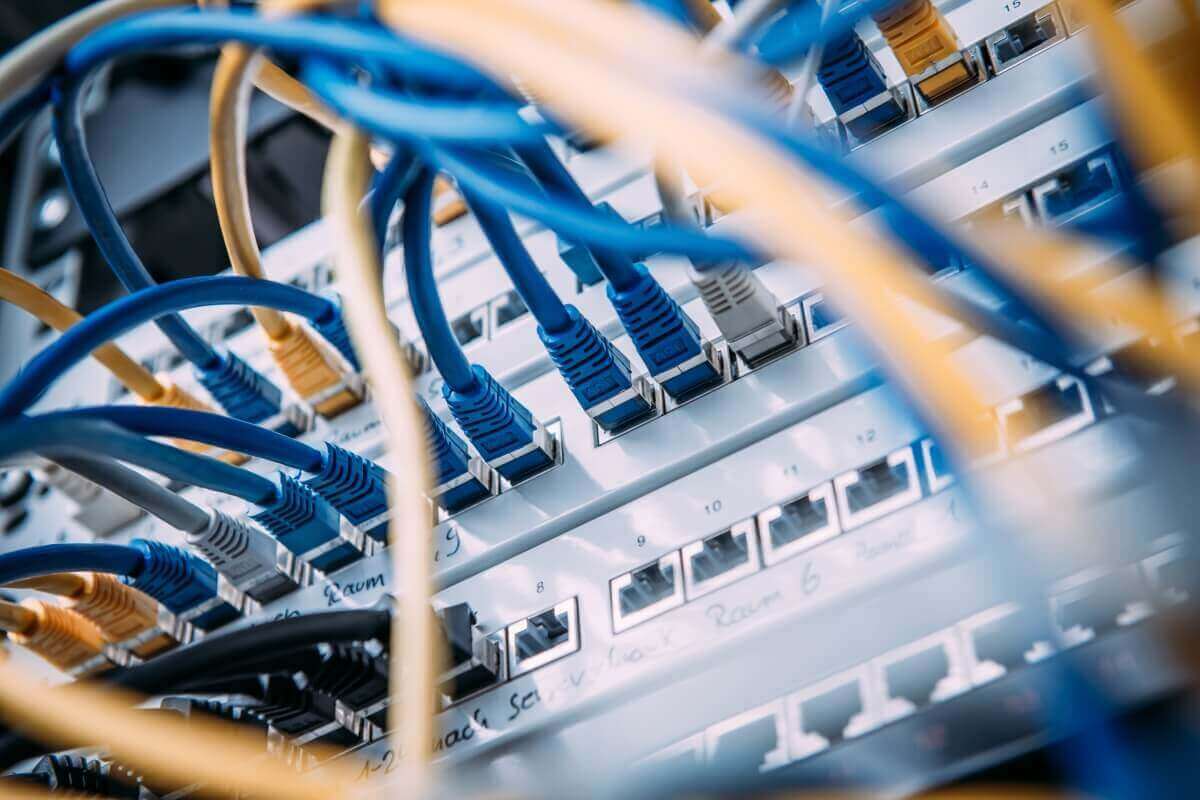 Netzwerk-Patchfeld mit blauen Netzwerkkabeln in einem betreuten Serverschrank.