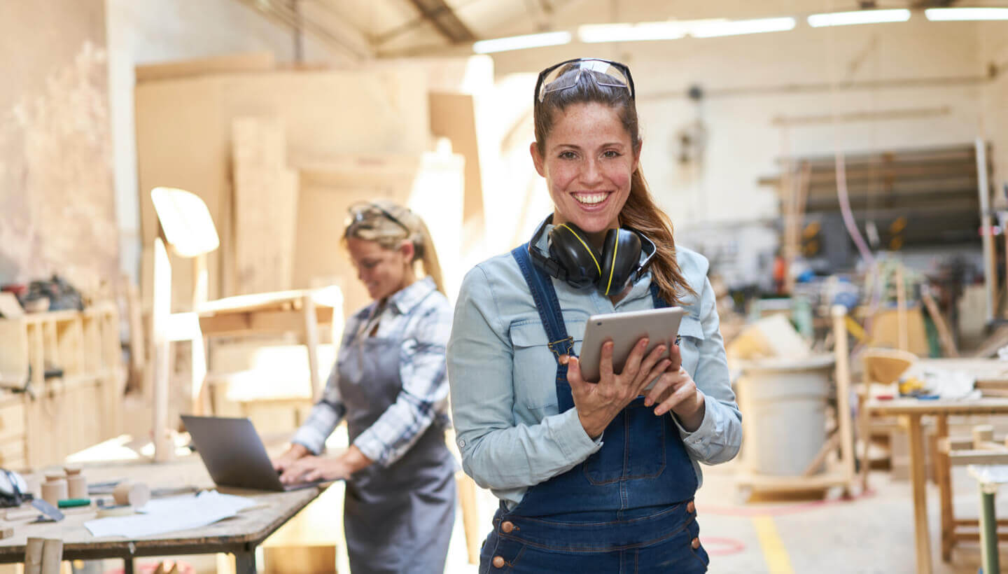 Handwerkerin mit Tablet in einer Werkstatt