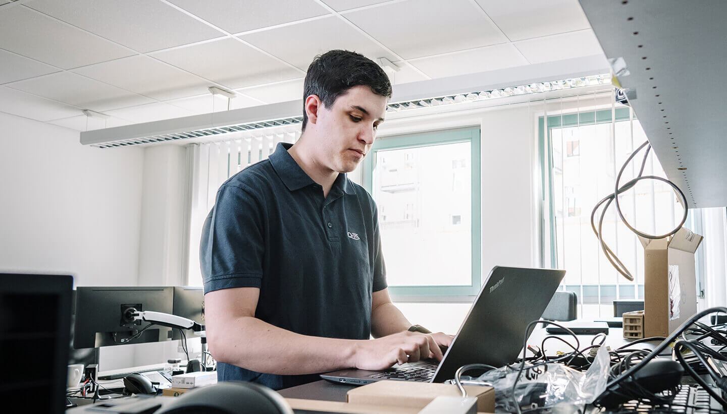 QITEC-Mitarbeiter arbeitet am Laptop im Büro