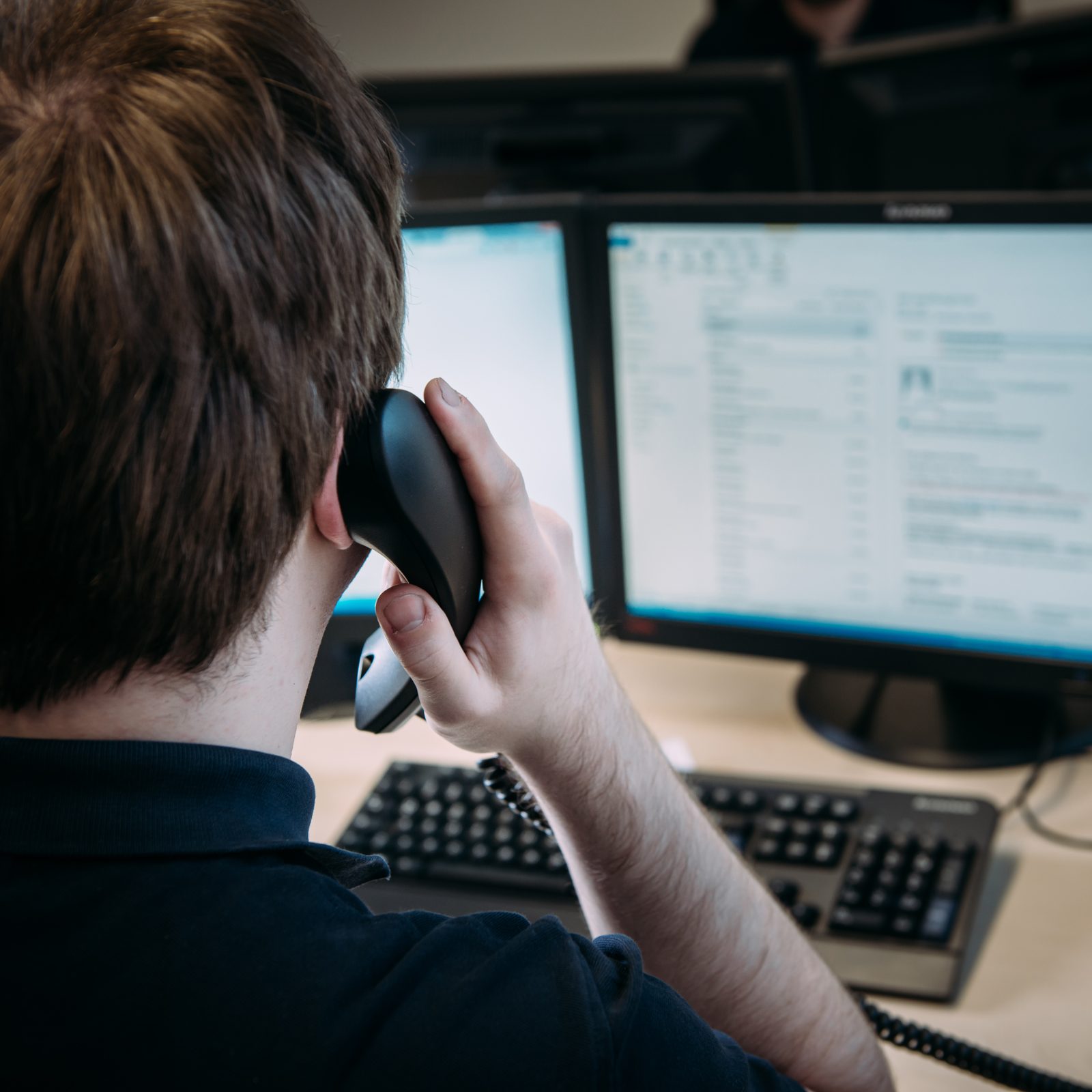 Mitarbeiter telefoniert am Arbeitsplatz vor dem Postfach
