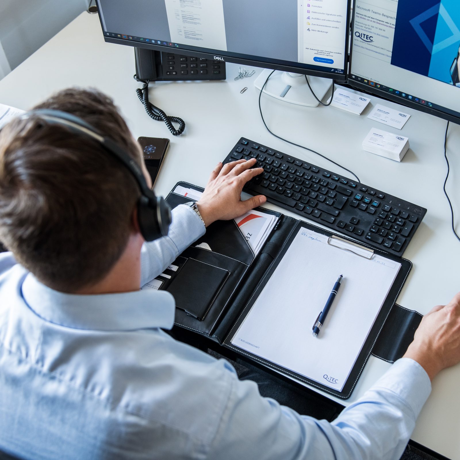 Mitarbeiter mit Headset am Arbeitsplatz in einer Teams-Besprechung